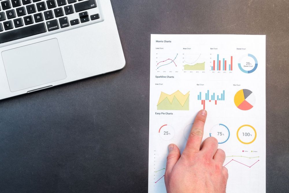 Hand zeigt auf eine ausgedruckte Auswertung mit Diagrammen