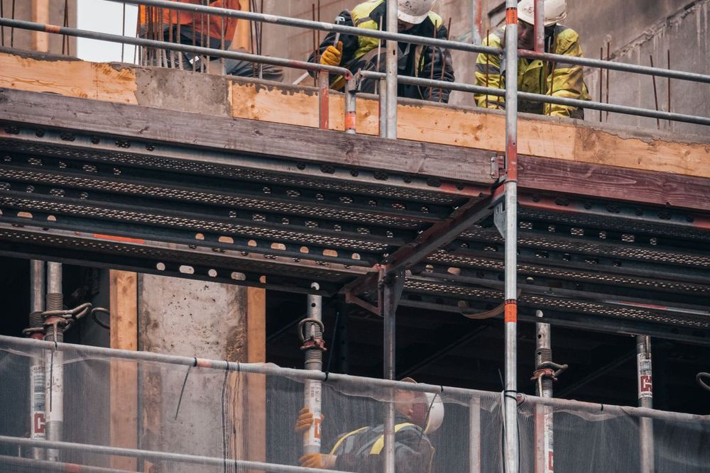 Bauarbeiter auf einem Gerüst an einer Baustelle