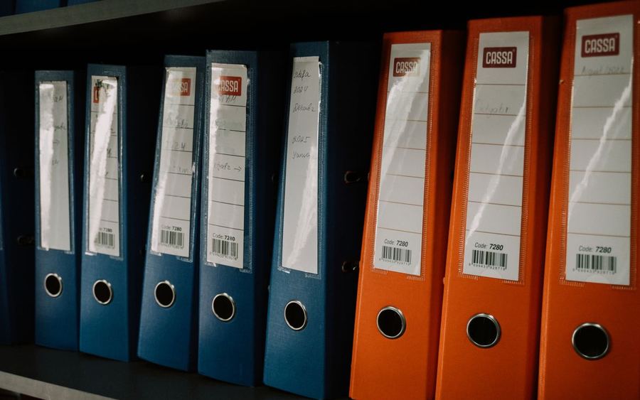 Eine Reihe beschrifteter Ordner in einem Büroregal